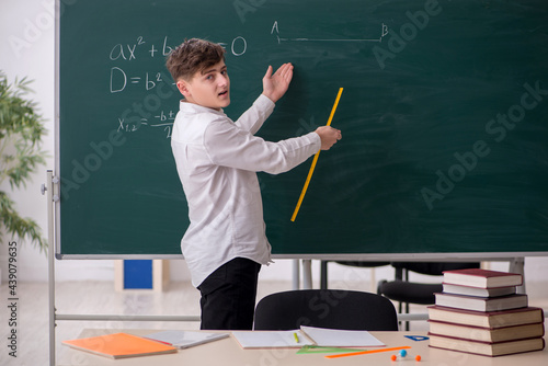 Cuadro en lienzo Schoolboy studying geometry in front of blackboard