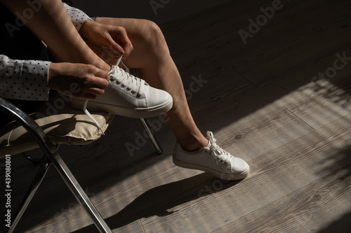 Woman put on new white leather sneakers