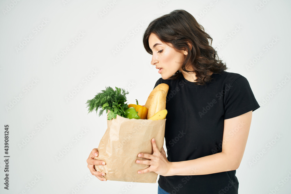 brunette in a black t-shirt package with groceries delivery supermarket brunette in a black t-shirt package with groceries delivery supermarket