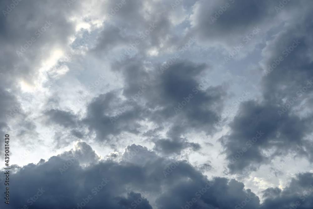 Fototapeta premium Dark sky full of clouds before the rain. Rain clouds and contrasting sunshine. Rain clouds.