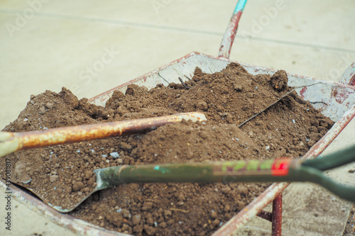 Closeup pile of soil on the steel shovels in the wheelbarrow