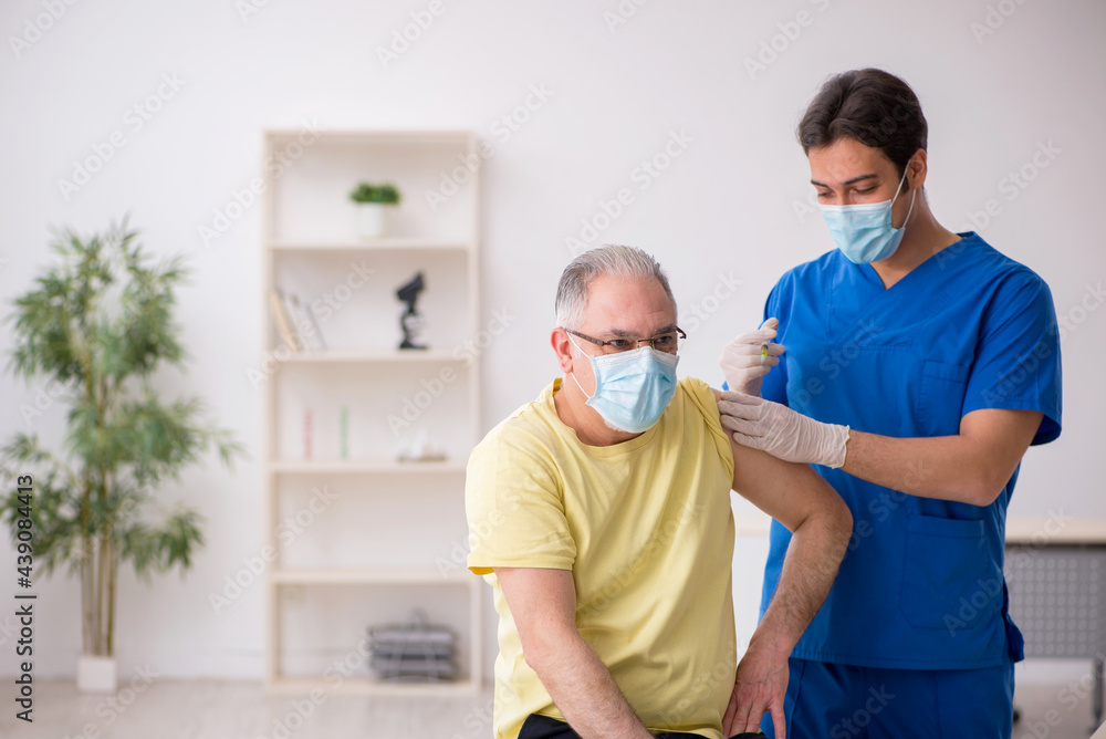 Fototapeta premium Old male patient visting young male doctor in vaccination concep