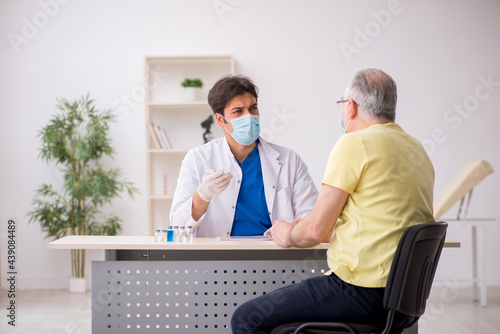 Old male patient visting young male doctor in vaccination concep