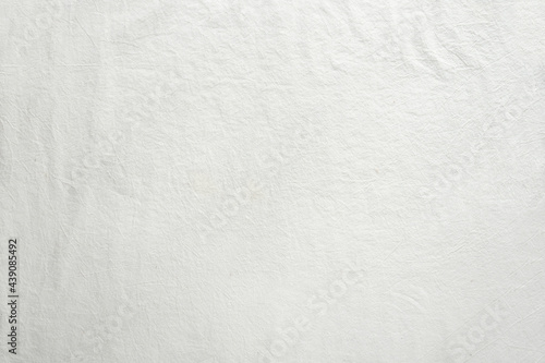 Off white cotton textile background. Flat lay, top view, textured textile backdrop. Copy-space, place for text on fabrique.