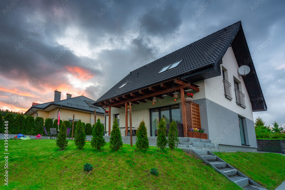 A modern single family house with a garden at sunset A modern single family house with a garden at sunset