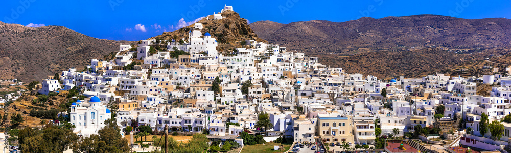 Picturesque authentic Ios island. View of scenic old town Chora with whitewashed houses and blue churches