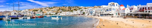 Mykonos island. Greece summer holidays. Panorama of old port in downtown. view with boats bars and restaurants. Cyclades. June 2021
