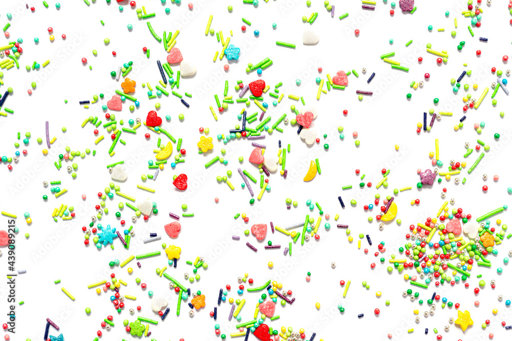 Bright background of multi-colored sweet sprinkles of different shapes in the form of hearts, stars, moon, flowers, round balls and sticks isolated.