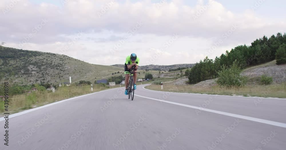 Triathlon sportsman athlete cyclist riding professional racing bicycle. Triathlon sportsman athlete cyclist riding professional racing bicycle.