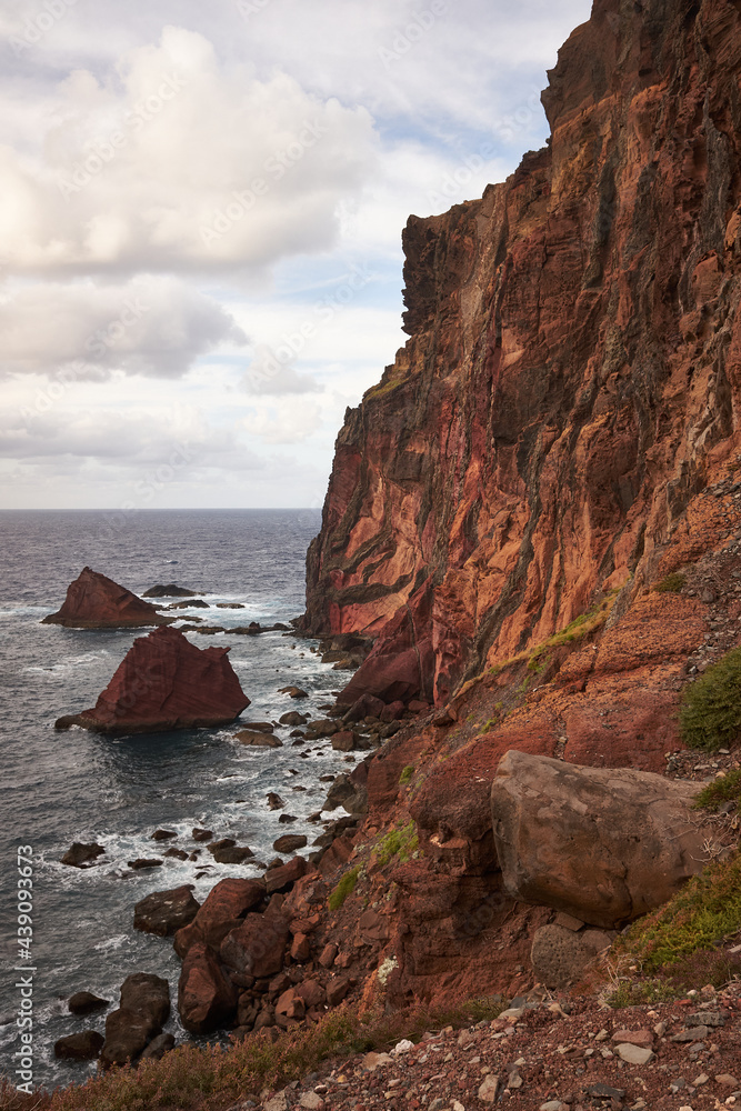 East Madeira coast landscape view with cliffs, rocks and sea at sunset. Ponta de São Lourenço. Atlantic ocean. Favorite touristic destination. Vertical photo orientation. East Madeira coast landscape view with cliffs, rocks and sea at sunset. Ponta de São Lourenço. Atlantic ocean. Favorite touristic destination. Vertical photo orientation.