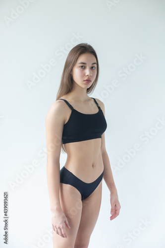 Natural beauty brunette model no make up in swimsuit posing in studio on isolated background. Model tests, natural no make up models concept