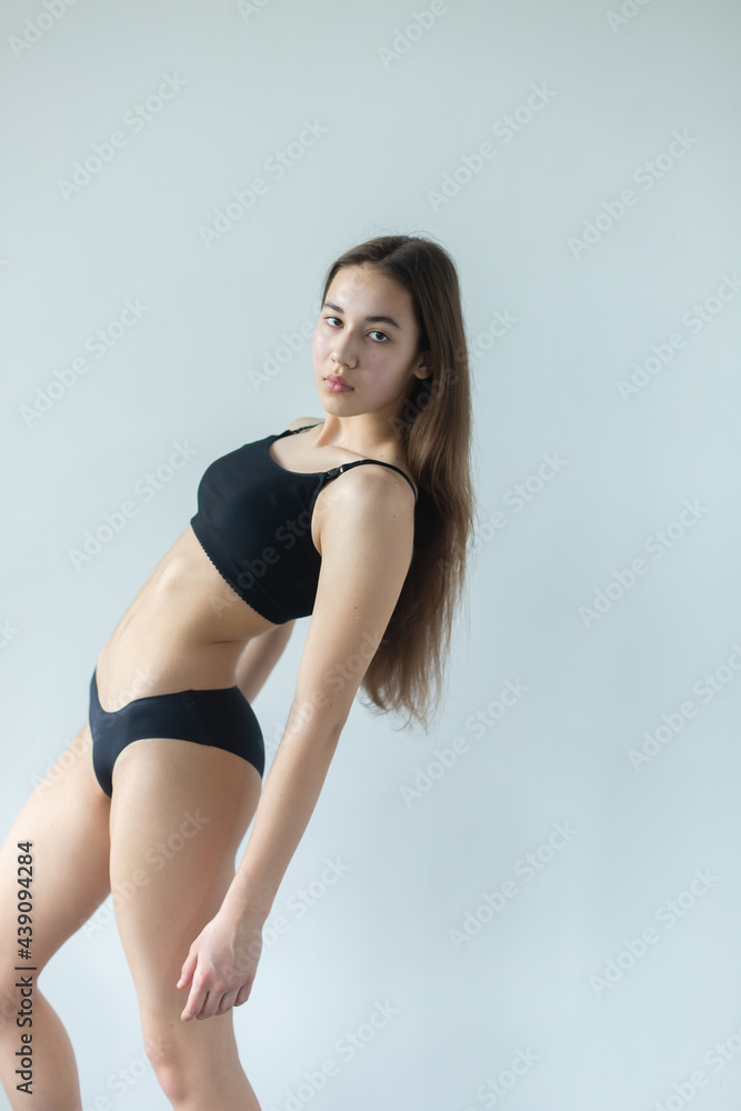 Natural beauty brunette model no make up in swimsuit posing in studio on isolated background. Model tests, natural no make up models concept