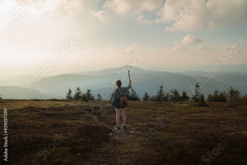Woman on the summit of Králický Sněžník between Poland and the Czech Republic, at sunset, high mountain meadow, with Czarna Gora in the background. Classic hiking with a backpack. © Gigo Velasco Tablado