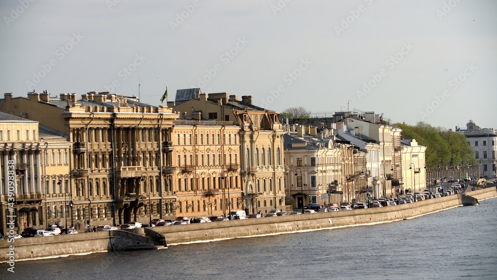 Embankment of the city of Saint Petersburg, Russia. Evening city in the sunset sunlight. Canal of the old beautiful city. Cars moving on road city traffic.