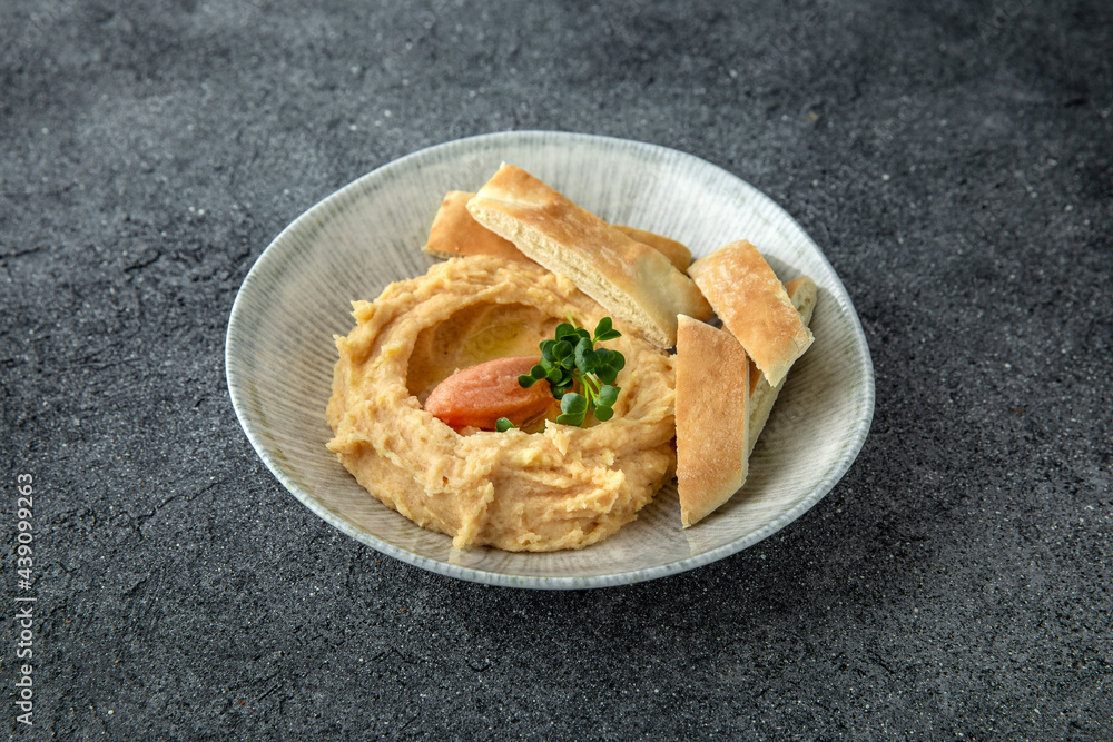 Hummus with turkey or chicken pate. Ready menu for the restaurant. Neutral gray blue textured background Hummus with turkey or chicken pate. Ready menu for the restaurant. Neutral gray blue textured background