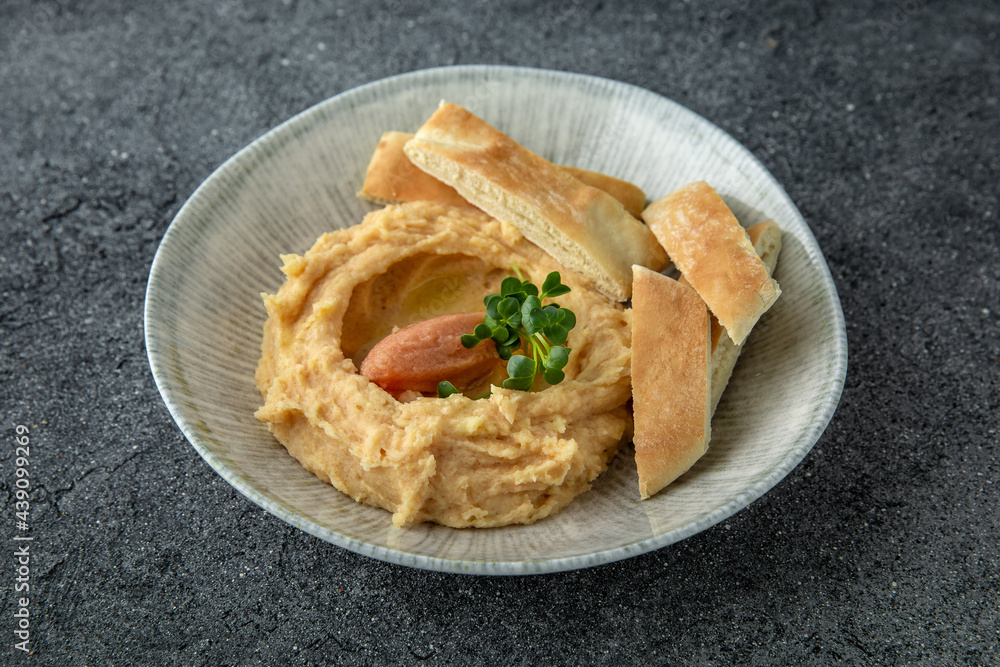 Hummus with turkey or chicken pate. Ready menu for the restaurant. Neutral gray blue textured background Hummus with turkey or chicken pate. Ready menu for the restaurant. Neutral gray blue textured background