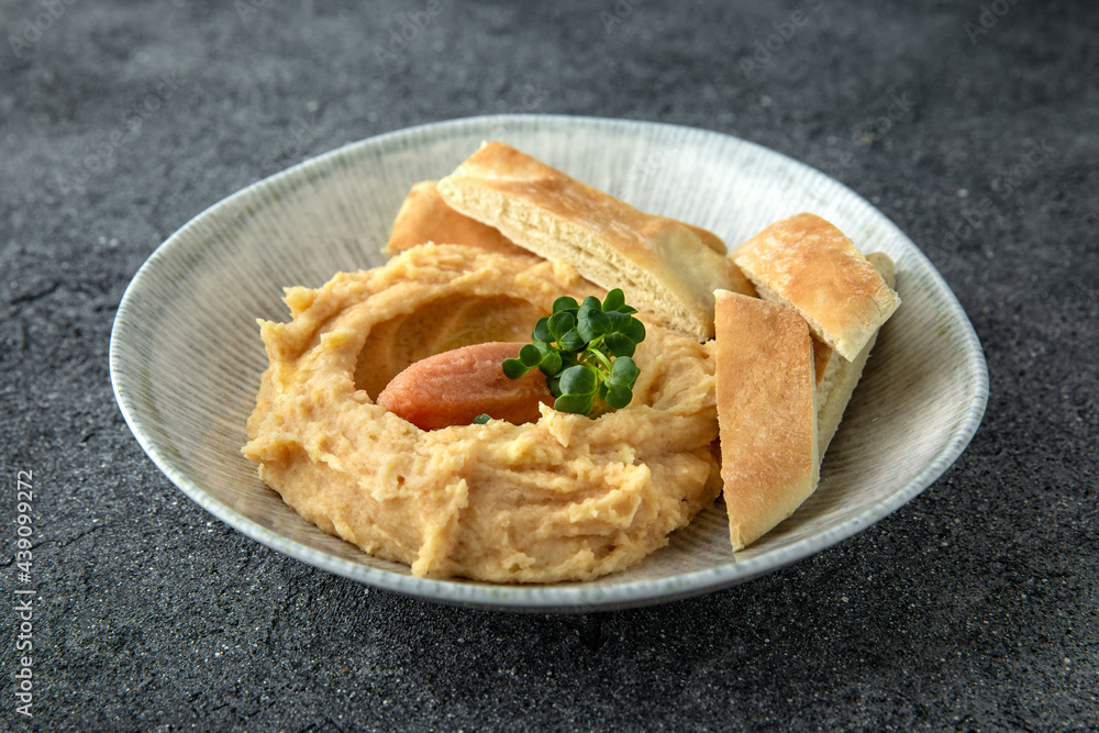 Hummus with turkey or chicken pate. Ready menu for the restaurant. Neutral gray blue textured background Hummus with turkey or chicken pate. Ready menu for the restaurant. Neutral gray blue textured background