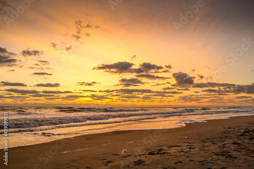 Bright ocean sunrise with spotty clouds © Jason Schronce