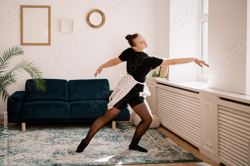 Teenager girl practicing ballet online classes at home. Woman dancing indoors