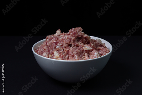 Fresh minced meat on a black background. Minced pork meat.