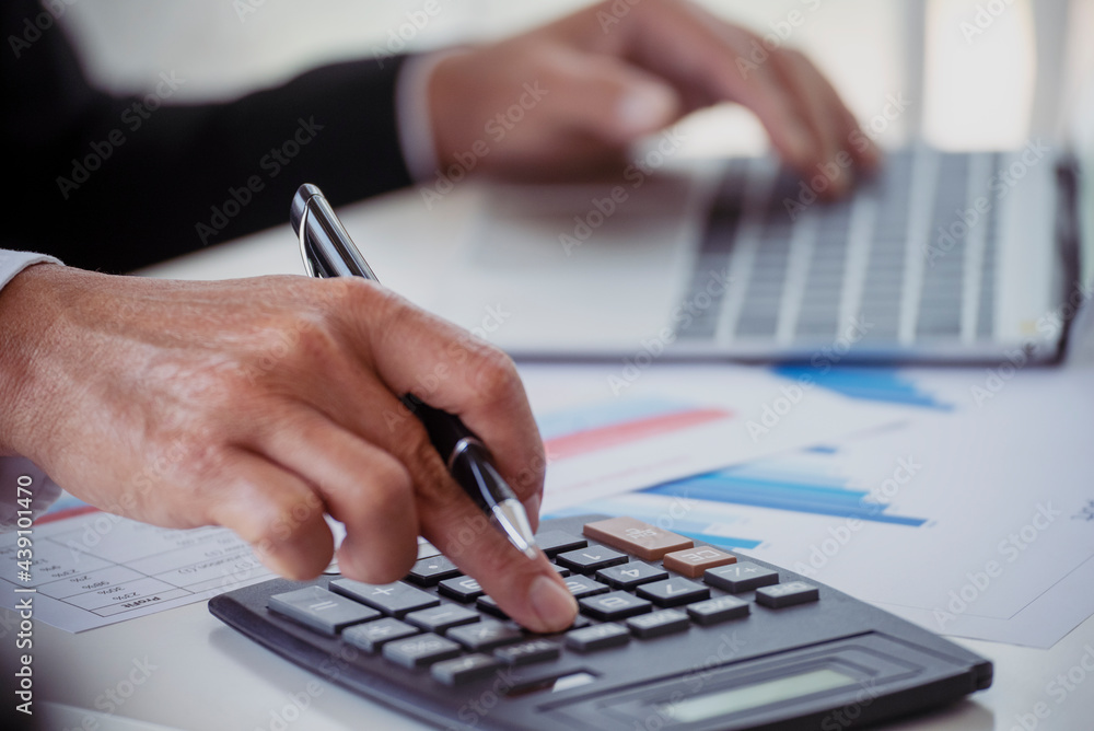 Close up business man hands using calculator counting tax financial bill. Man hands calculating number, data, graph, chart audit planning accountancy on business report. Tax audit Finacial concept. Close up business man hands using calculator counting tax financial bill. Man hands calculating number, data, graph, chart audit planning accountancy on business report. Tax audit Finacial concept.