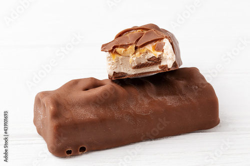 фотографія Two chocolate ice cream bars with caramel and peanuts on white background close