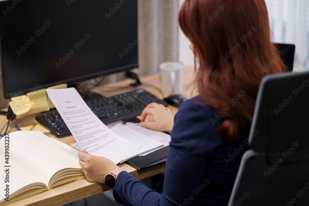 Portrait of businesswoman with laptop writes on a document at her office. Portrait of businesswoman with laptop writes on a document at her office.