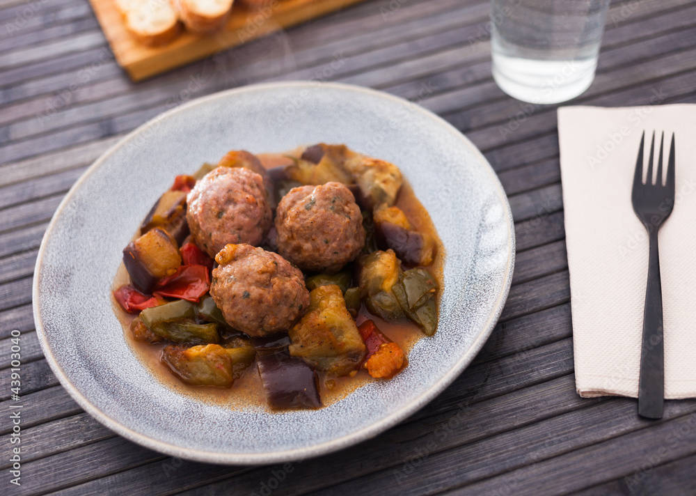 baked meatballs with stewed eggplant, zucchini, green peppers and tomatoes with haze in bowl baked meatballs with stewed eggplant, zucchini, green peppers and tomatoes with haze in bowl