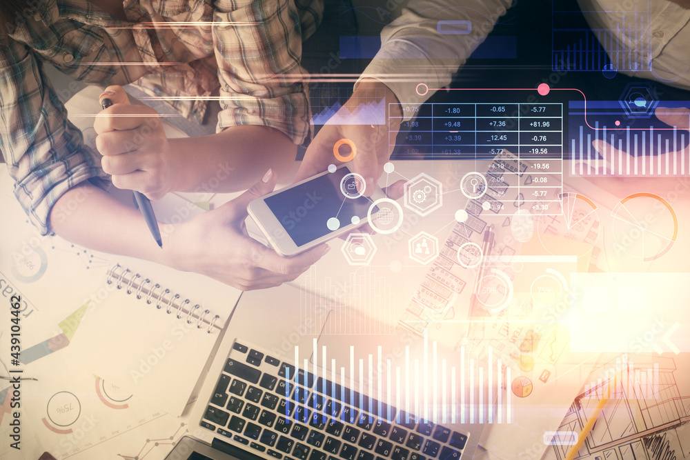 Double exposure of data theme hologram drawing and man and woman working together holding and using a mobile device. Double exposure of data theme hologram drawing and man and woman working together holding and using a mobile device.
