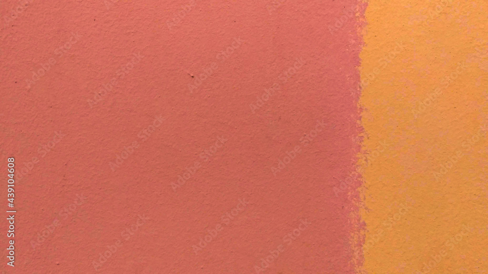 Fototapeta premium Background from a fragment of a wall of pink and yellow colors with stains. Yellow occupies one third on the right. The texture is rough uneven. Copy space.