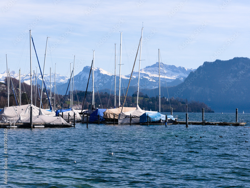 Sailing ships with tarpaulins on Lake Lucerne with snow covered Alps in the background