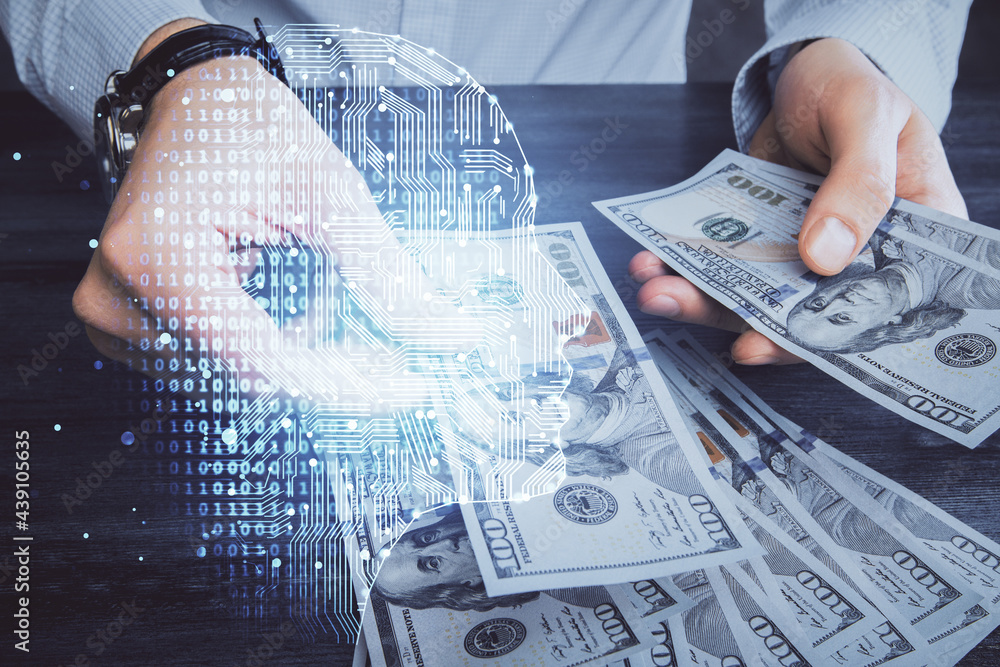 Multi exposure of brain drawing hologram and us dollars bills and man hands. Ai invest concept Multi exposure of brain drawing hologram and us dollars bills and man hands. Ai invest concept