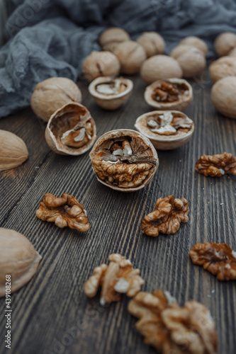 Walnuts lie on a wooden surface. Chopped walnuts on a wooden table top. © Valeriia