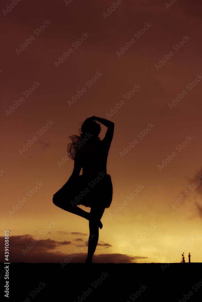 Silhouette of young ballerina dancing and having fun outdoors