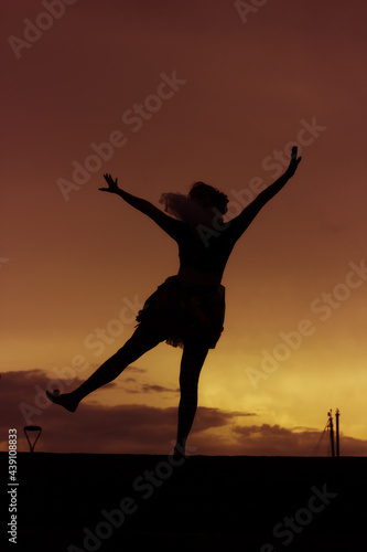 Silhouette of young ballerina dancing and having fun outdoors