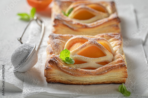 Tasty puff pastry baked with peaches. Unique yummy cake.