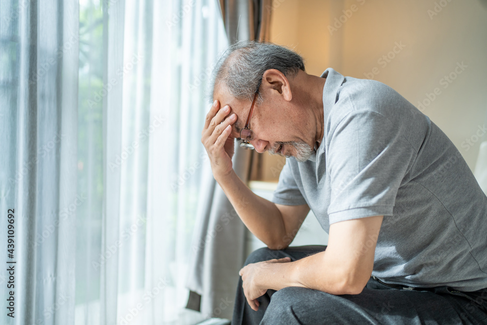 Asian old man feeling headache from migraine, sitting alone at home.
Asian old man feeling headache from migraine, sitting alone at home.