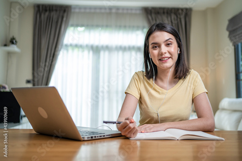 Portrait of Asian homeschool girl learn online at home look at camera.