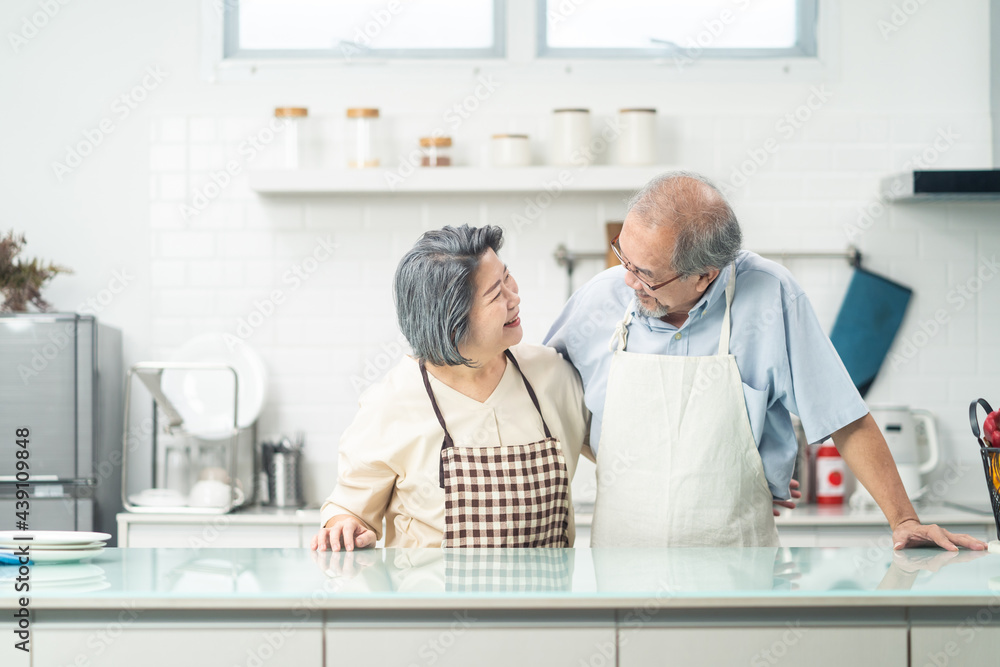 Asian Senior older Couple smile, look at each other in kitchen at home Asian Senior older Couple smile, look at each other in kitchen at home