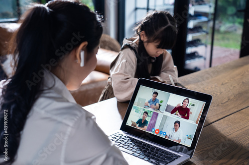 Asian business woman talk to virtual video with daughter study beside.
