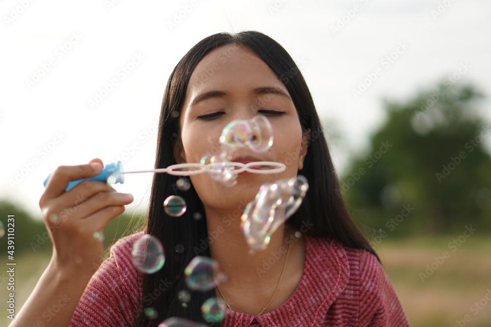 Asian woman blowing soap bubbles every green grass background Asian woman blowing soap bubbles every green grass background