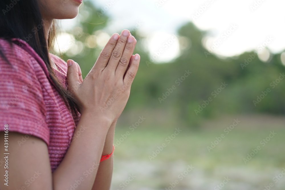 Asian woman's hand asking for blessings from God green meadow background Asian woman's hand asking for blessings from God green meadow background