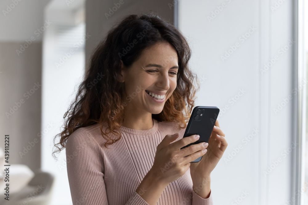 Happy millennial Latino woman hold cellphone look at screen browse wireless internet on gadget. Smiling Hispanic female use smartphone talk speak on video webcam online virtual call on modern device. Happy millennial Latino woman hold cellphone look at screen browse wireless internet on gadget. Smiling Hispanic female use smartphone talk speak on video webcam online virtual call on modern device.