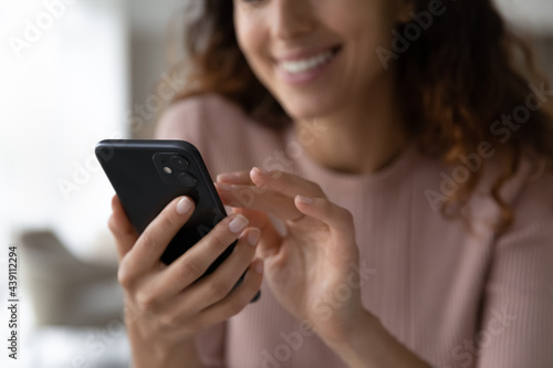 Crop close up woman hold use smartphone text message online on modern gadget. Smiling female browse wireless internet on cellphone device, talk speak on webcam video call. Technology concept. photo