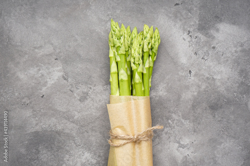 Green fresh asparagus on gray background  close-up. Top view