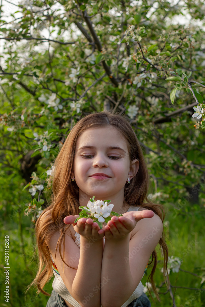 Happy girl enjoying sunny day in the park among blossom trees Happy girl enjoying sunny day in the park among blossom trees