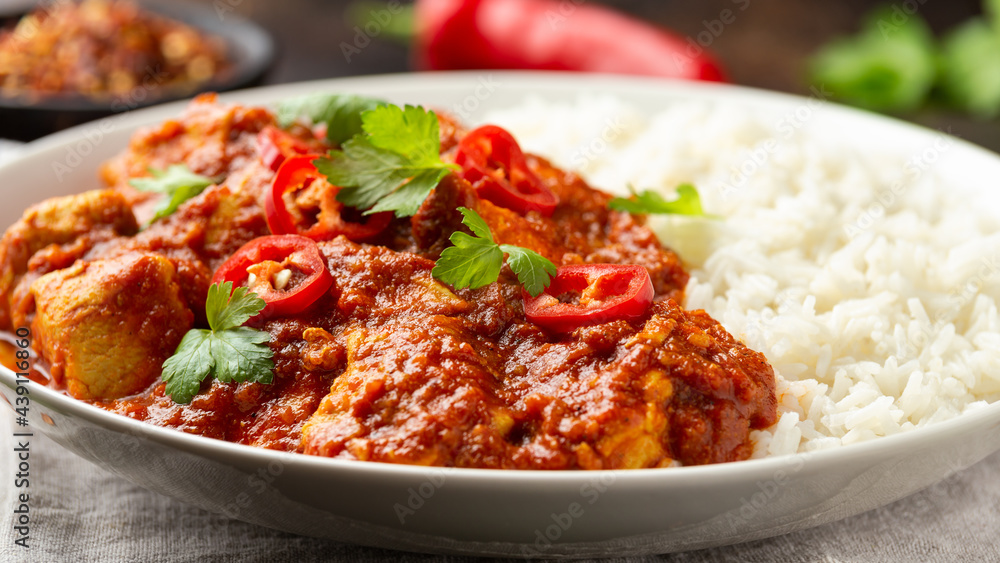 Spicy Chicken Pathia curry with basmati rice in a white plate. healthy food. Spicy Chicken Pathia curry with basmati rice in a white plate. healthy food.