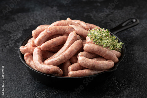 Εκτύπωση καμβά Raw pork chipolata sausage in cast iron skillet frying pan