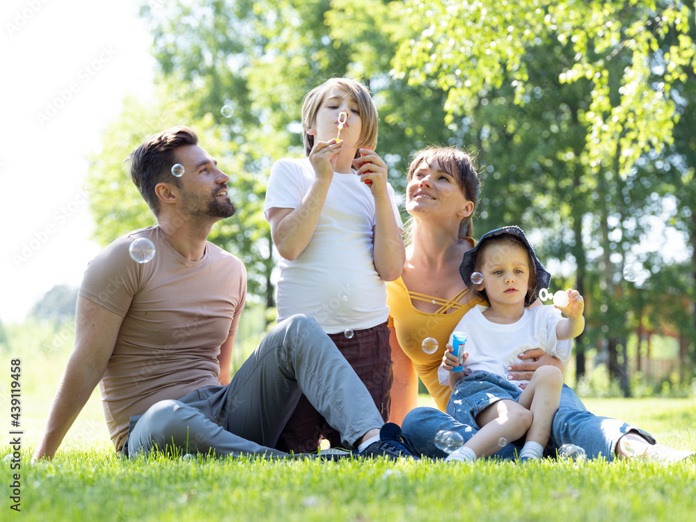 Family start soap bubble on meadow Family start soap bubble on meadow