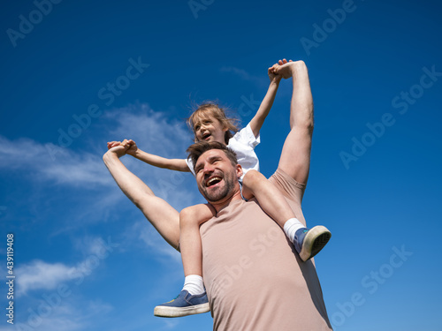 Little girl sit on neck of father